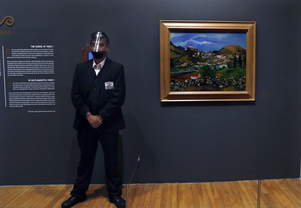 Un guardia de museo junto a una pintura de Suzanne Valadon en la exposición "El París de Modigliani y sus contemporáneos" en el Museo del Palacio de Bellas Artes en la Ciudad de México el lunes 7 de septiembre de 2020. El museo presenta su primera exposición tras el brote de coronavirus con una gran muestra del pintor italiano. (Foto AP/Marco Ugarte)