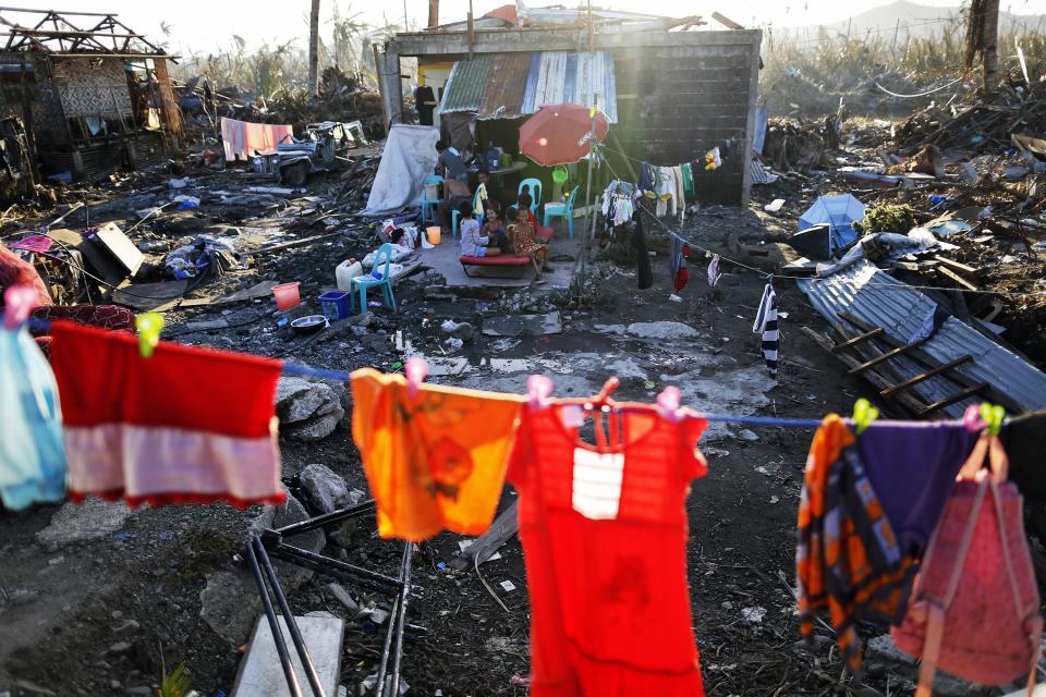 Survivors pass the time outside the ruins of their homes, destroyed by Super Typhoon Haiyan in Palo, south of Tacloban