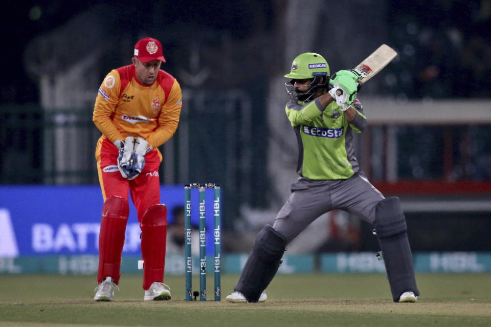 Lahore Qalandars batsman Mohammad Hafeez, right, plays a shot while Islamabad United wicketkeeper Luke Ronch watches during their Pakistan Super League T20 cricket match at Gaddafi stadium in Lahore, Pakistan, Sunday, Feb. 23, 2020. (AP Photo/K.M. Chaudary)