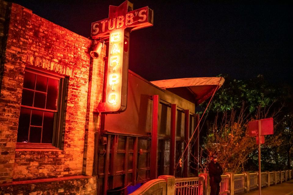 A staff member stands outside Stubb's Bar-B-Q on Tuesday, Nov. 17, 2020, in Austin. Dave Chappelle announced a three night run in Austin. Attendees have to have a rapid COVID-19 test done before being able to enter.