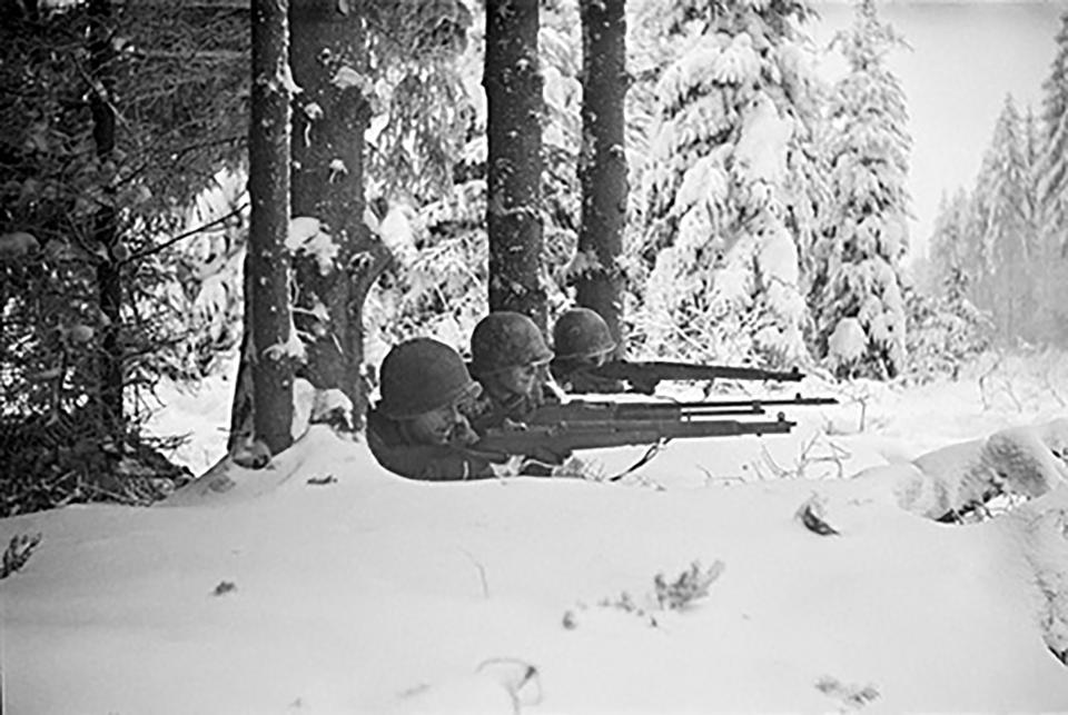 In this 1944 photo titled "Firing Line" by photographer Tony Vaccaro, shows American soldiers in Germany's Hurtgen Forest. Vaccaro, 97, was thrown into WWII with the 83rd Infantry division which fought, like Charles Shay, in Normandy, and then came to Schmetz's doorstep for the Battle of the Bulge. On top of his military gear, he also carried a camera, and became a fashion and celebrity photographer after the war. COVID-19 caught up with him last month. Like everything bad life threw at him, he shook it off, attributing his survival to plain "fortune." (Photo courtesy Tony Vaccaro via AP)