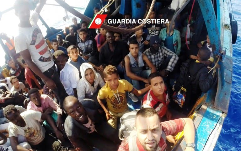 Migrants wait to be rescued on a boat in the Mediterranean Sea during a rescue operation by the Italian coastguard. Around 6,500 migrants were rescued off the coast of Libya on August 29, in one of the busiest days of life-saving in recent years