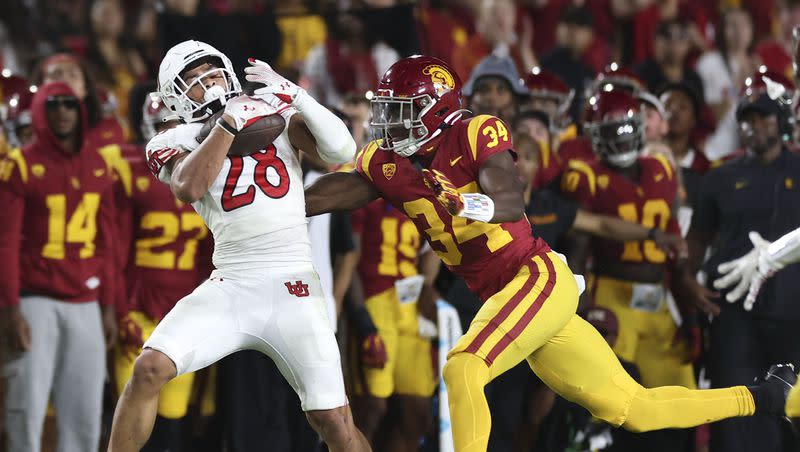 Utah’s Sione Vaki (28) hauls in a pass before getting tackled by USC defensive end Braylan Shelby (34) at the Los Angeles Memorial Coliseum on Saturday, Oct. 21, 2023.