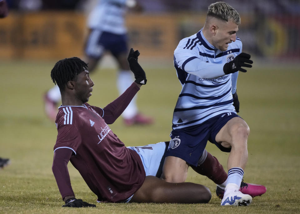 Colorado Rapids forward Darren Yapi, left, tries to tackle Sporting Kansas City midfielder Marinos Tzionis during the first half of an MLS soccer match Saturday, March 4, 2023, in Commerce City, Colo. (AP Photo/David Zalubowski)