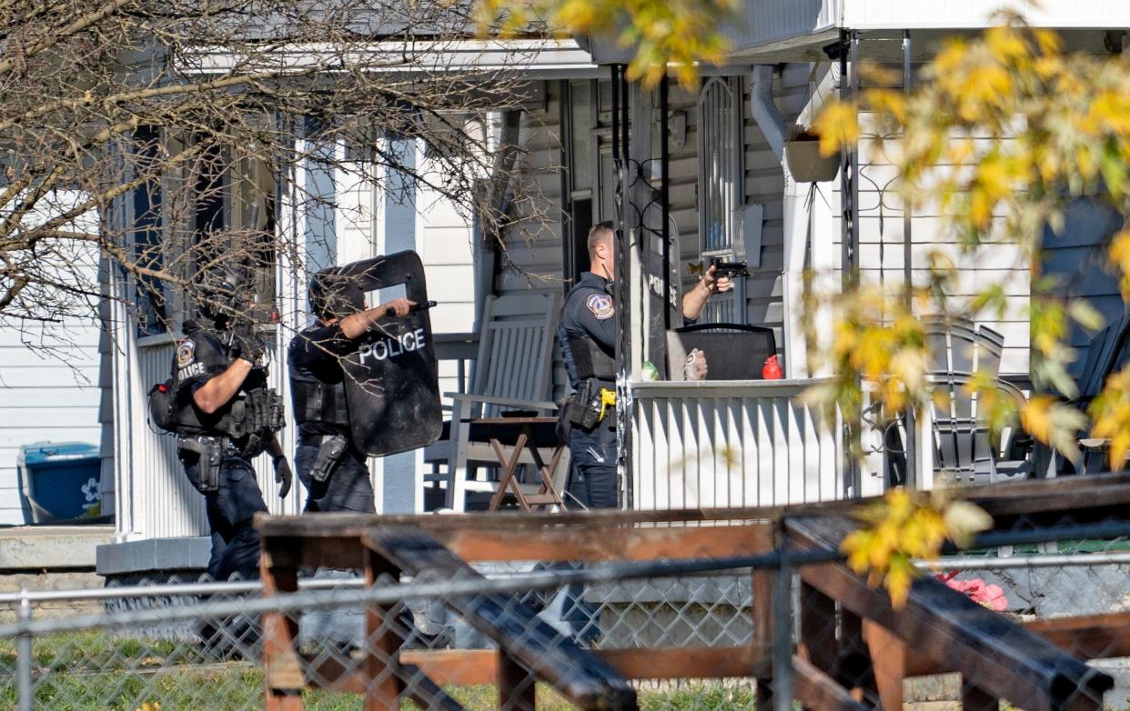 SWAT officers move into a house in the 3900 block of Caroline Avenue for a security sweek as police work the scene of a police action shooting Friday, Nov. 10, 2023 in the 3900 block of Caroline Avenue.