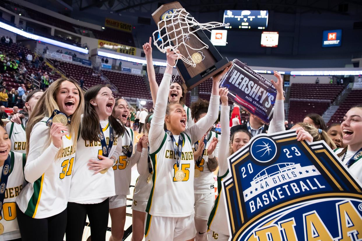 The Lansdale Catholic Crusaders celebrate with their trophy after winning the PIAA Class 4A Girls' Basketball Championship against Blackhawk at the Giant Center on March 25, 2023, in Hershey. The Crusaders won, 53-45.