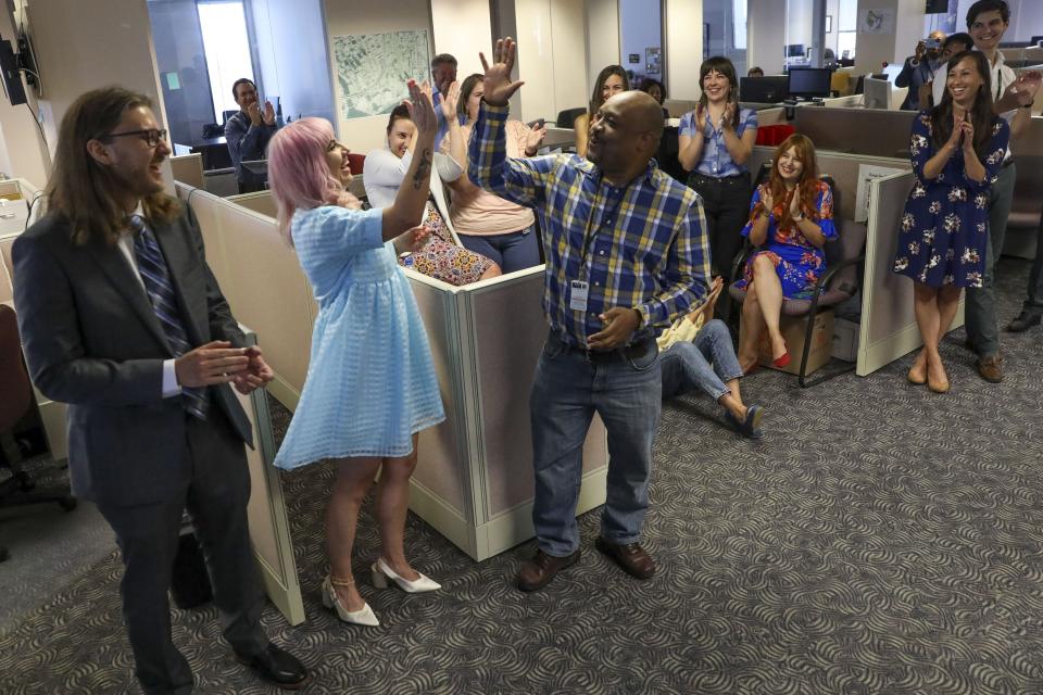 Tampa Bay Times reporters Corey G. Johnson, center, Rebecca Woolington, second left, and Eli Murray, left, are announced as the winners of the Pulitzer Prize for investigative reporting on Monday, May 9, 2022. The winning series, "Poisoned," exposed dangers at Florida's only lead smelter. This marked the 14th Pulitzer Prize awarded to the Times. (Ivy Ceballo/Tampa Bay Times via AP)