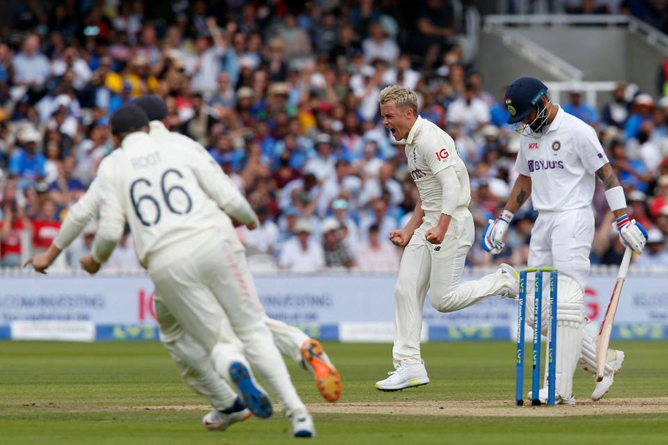 England's Sam Curran (C) celebrates after taking the wicket of India's captain Virat Kohli (R) during play on the fourth day of the second cricket Test match  between England and India at Lord's cricket ground in London on August 15, 2021. (Photo by IAN KINGTON/AFP via Getty Images)