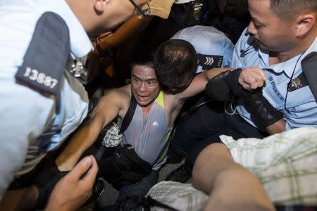 A protester is taken away by police officers after staying overnight at Hong Kong's financial Central district, in this July 2, 2014 file picture. REUTERS/Tyrone Siu/Files