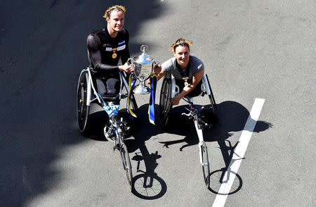 Marcel Hug of Switzerland, winner of the men's wheelchair division, and Manuela Schar, also of Switzerland, winner of the women's wheelchair division, hold a trophy of the 121st Boston Marathon in Boston, Massachusetts, U.S., April 17, 2017. REUTERS/Gretchen Ertl