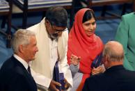 Norway's King Harald (R) speaks to Nobel Peace Prize laureates Kailash Satyarthi (2nd L) and Malala Yousafzai during the Nobel Peace Prize awards ceremony at the City Hall in Oslo December 10, 2014. Pakistani teenager Yousafzai, shot by the Taliban for refusing to quit school, and Indian activist Satyarthi received their Nobel Peace Prizes on Wednesday after two days of celebration honouring their work for children's rights. REUTERS/Suzanne Plunkett (NORWAY - Tags: SOCIETY ROYALS)