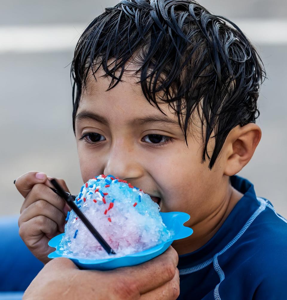 Antonio Rodreguez eats some patriotic ice with matching colored sprinkles in an effort to stay cool during the Celebration Under the Stars at Fountains of Gateway, Monday, July 4, 2022.