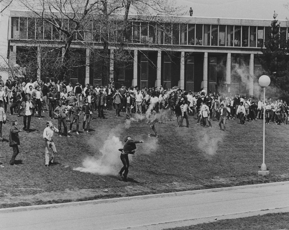 A student throws back a tear gas canister below Taylor Hall on the Kent State campus on May 4, 1970. Protesters clashed with Ohio National Guard units that were sent to campus to quell unrest.