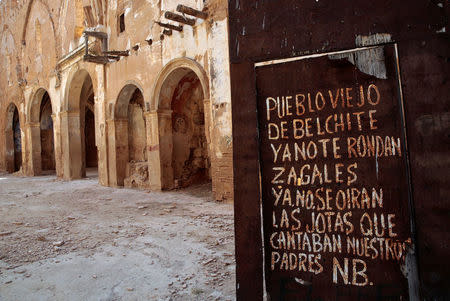 A graffiti is seen on the entrance door of San Martin de Tours church in the old village of Belchite, in northern Spain, October 3, 2016. REUTERS/Andrea Comas