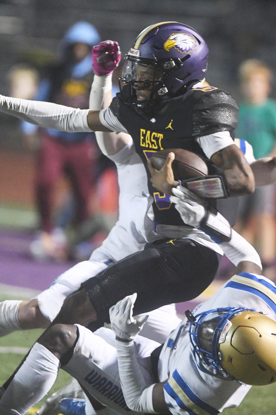 East quarterback Zymier Jackson scrambles out of the pocket and backs his way into the end zone for a 21-14 lead for East.