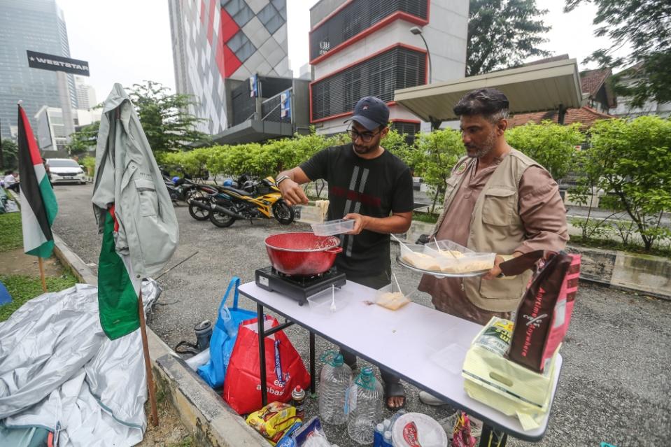 Picketer Syed Sheikh 34 (left) prepares breakfast during the Kepung Demi Palestin picket at Jalan Tun Razak in Kuala Lumpur December 27, 2023. — Picture by Yusof Mat Isa