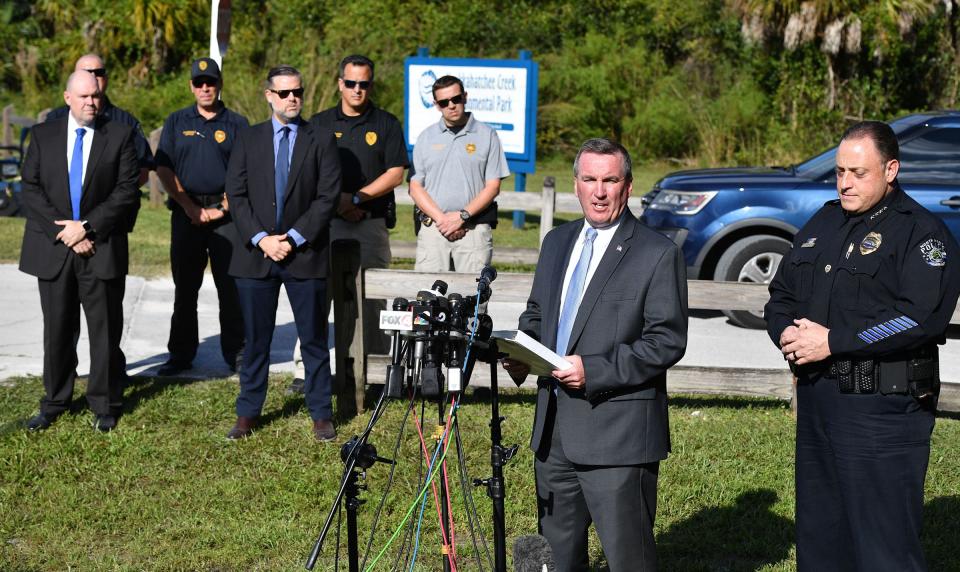 Michael McPherson with the FBI is joined by North Port Police Chief Todd Garrison during a news conference at the entrance to the Myakkahatchee Creek Environmental Park in North Port, Florida, on Oct. 20, 2021. McPherson announced that a body had been found along with a backpack and notebook belonging to Brian Laundrie, a fugitive sought in connection with the death of Gabby Petito.