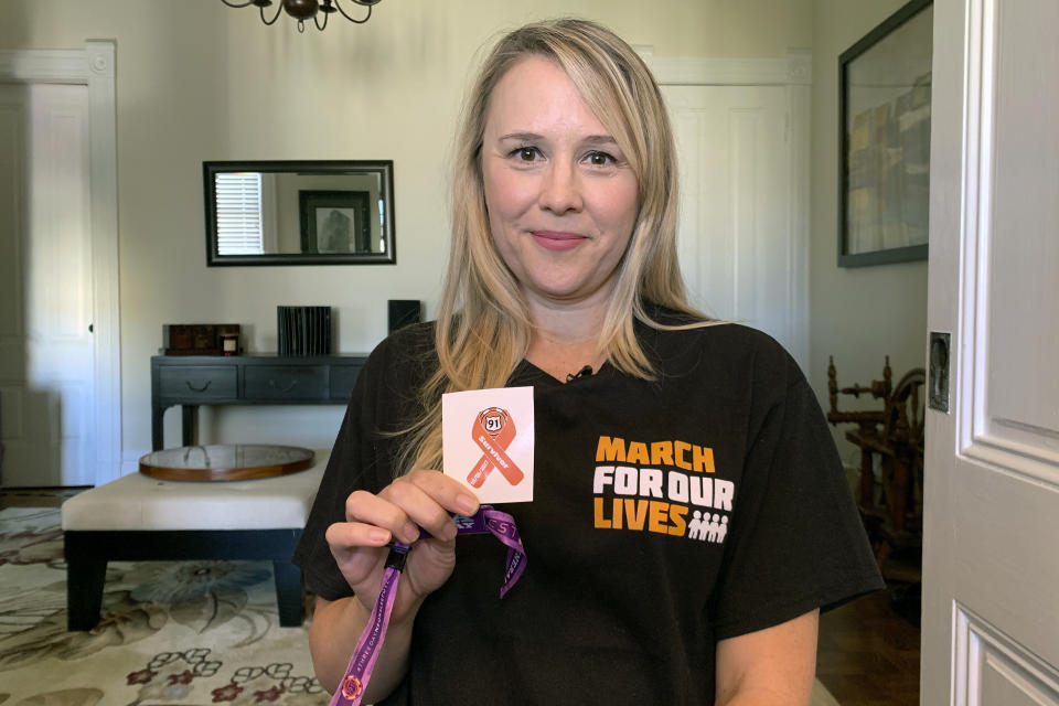 Shooting survivor Stephanie Wellek holds a sticker created to identify survivors of the October 2017 massacre at a Las Vegas country music festival at her home in San Francisco, Thursday, Oct. 3, 2019. Wellek is part of a lawsuit and settlement with MGM Resorts International. (AP Photo/Terry Chea)