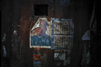 A partially damaged portrait of former leader Mao Zedong is seen inside an abandoned old house belonging to a member of Yi ethnic minority, in Qingshui village in Ganluo County, southwest China's Sichuan province, on Sept. 10, 2020. Communist Party Xi Jinping’s smiling visage looks down from the walls of virtually every home inhabited by members of the Yi minority group in a remote corner of China’s Sichuan province. Xi has replaced former leader Mao Zedong for pride of place in new brick and concrete homes built to replace crumbling traditional structures in Sichuan’s Liangshan Yi Autonomous Prefecture, which his home to about 2 million members of the group. (AP Photo/Andy Wong)