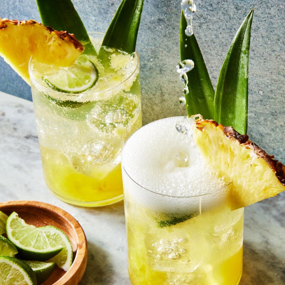 coconut pineapple spritz with a pineapple wedge and pineapple leaf garnish