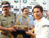 Sachin Tendulkar of India is presented with a memento by the commissioner of police during day three of the first Star Sports test match between India and The West Indies held at The Eden Gardens Stadium in Kolkata, India on the 8th November 2013. (BCCI Photo)