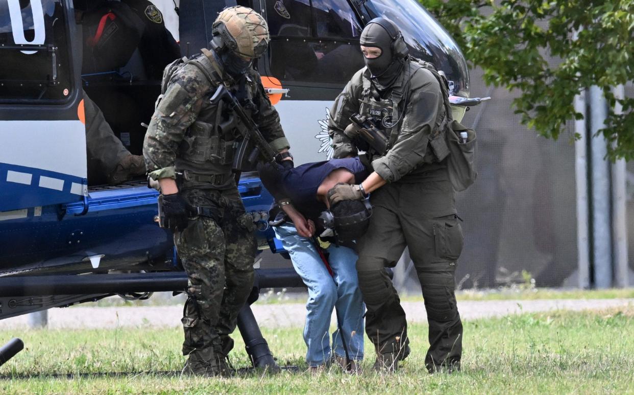 The suspect is taken by members of a special police unit from a helicopter to the office of the federal prosecutor in Karlsruhe on Sunday