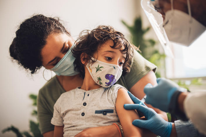 A health care worker gives a child a vaccine.