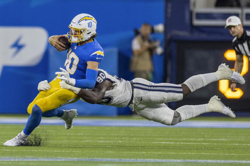 Cowboys defensive end DeMarcus Lawrence (90) chases down Chargers quarterback Justin Herbert in the fourth quarter.