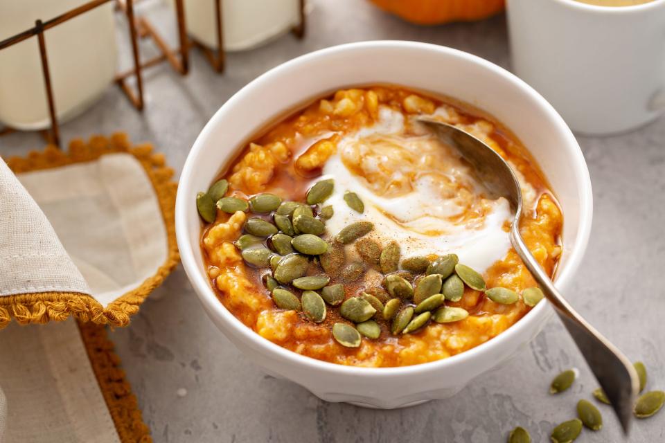 A bowl of oatmeal with pumpkin, pumpkin seeds, and cinnamon.