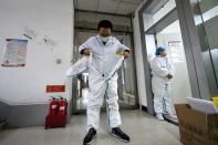 Worker puts on his protective suit before entering a laboratory at a centre for disease control and prevention in Taiyuan