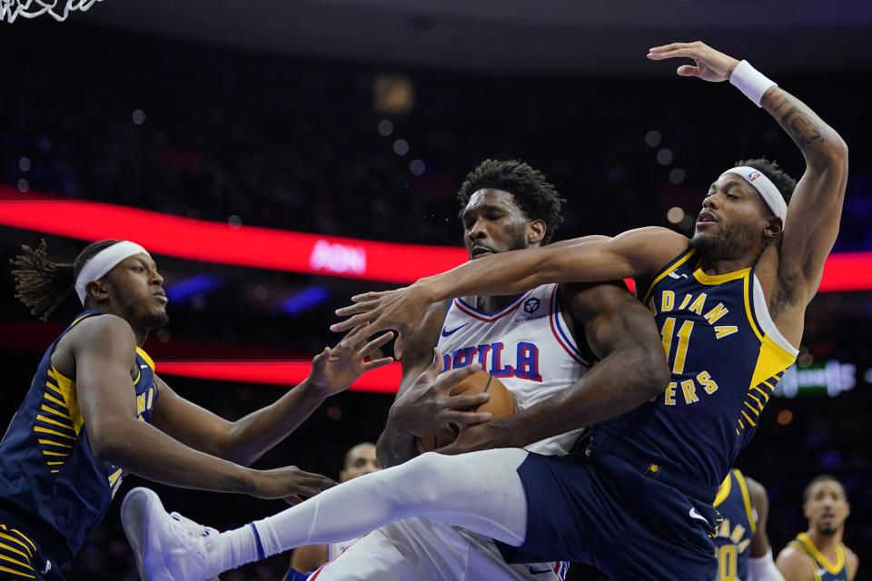 Philadelphia 76ers' Joel Embiid, center, battles for a rebound against Indiana Pacers' Bruce Brown, right, and Myles Turner during the first half of an NBA basketball game, Sunday, Nov. 12, 2023, in Philadelphia. (AP Photo/Matt Slocum)