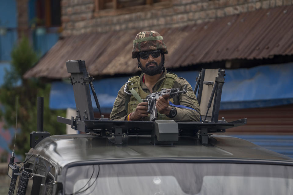 An Indian army soldier stands guard atop an armored vehicle near the house of his colleague Waseem Sarvar Bhat, who was killed in a gunfight with suspected rebels, in Bandipora, north of Srinagar, Indian controlled Kashmir, Saturday, Aug. 5, 2023. Three Indian soldiers were killed in a gunbattle with rebels fighting against New Delhi's rule in Kashmir, officials said Saturday, as authorities stepped up security on the fourth anniversary since India revoked the disputed region's special status. (AP Photo/Dar Yasin)