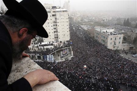 An ultra-Orthodox Jewish man looks down from a rooftop at a mass prayer in Jerusalem March 2, 2014. REUTERS/Darren Whiteside