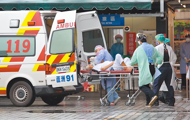 台北市本土確診病例持續下降，防疫急門診的就診人數也明顯下降，急診外病床壅塞情形不再，圖為一名患者在救護人員協助下送往急診搶救。（張鎧乙攝）