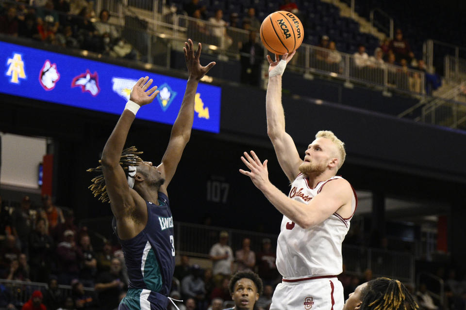 Charleston guard Dalton Bolon, right, shoots against UNC Wilmington guard Maleeck Harden-Hayes, left, during the first half of an NCAA college basketball game in the championship of the Colonial Athletic Association conference tournament, Tuesday, March 7, 2023, in Washington. (AP Photo/Nick Wass)