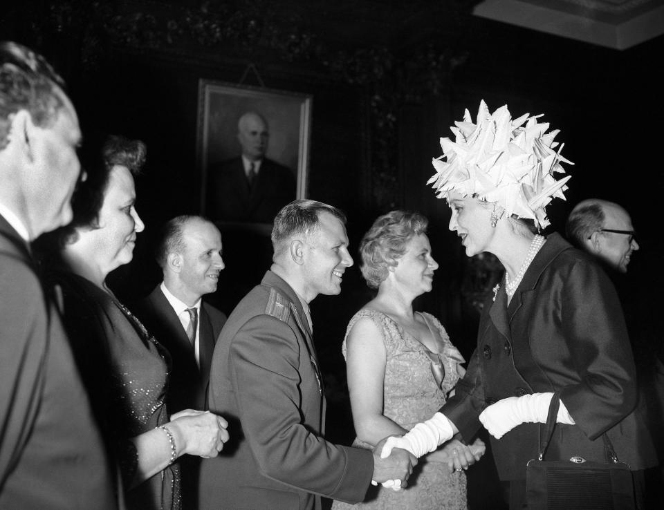 FILE - In this Tuesday, July 11, 1961 file photo, Mrs. John Profumo, formerly actress Valerie Hobson, now the wife of the Secretary of State for War, shakes hands with Major Yuri Gagarin, Russia's cosmonaut, at a reception given in Gagarin's honor at the Soviet Embassy in London. The successful one-orbit flight on April 12, 1961 made the 27-year-old Gagarin a national hero and cemented Soviet supremacy in space until the United States put a man on the moon more than eight years later. (AP Photo/Bob Dear, File)