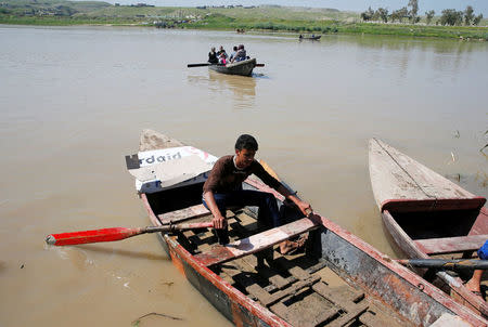 Displaced Iraqis from Mosul cross the Tigris by boat as flooding after days of rainfall has closed the city's bridges, at the village of Thibaniya, south of Mosul, Iraq April 16, 2017. REUTERS/Muhammad Hamed