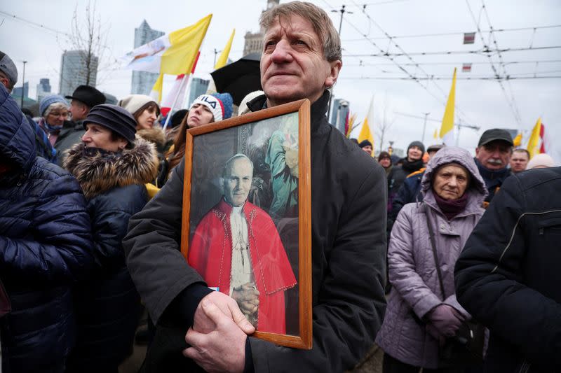 People march in defense of pope John Paul II on his death anniversary in Warsaw