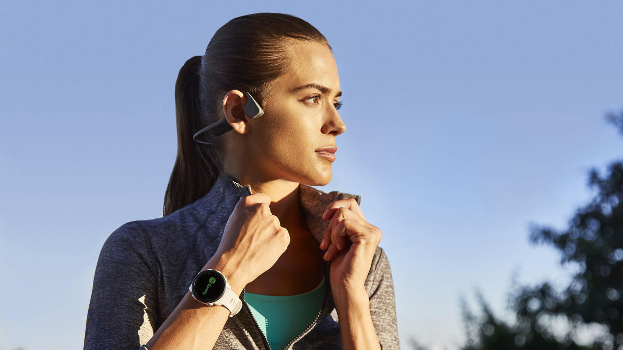  Young woman turning her collar up wearing the Garmin Forerunner 245 GPS running watch. 