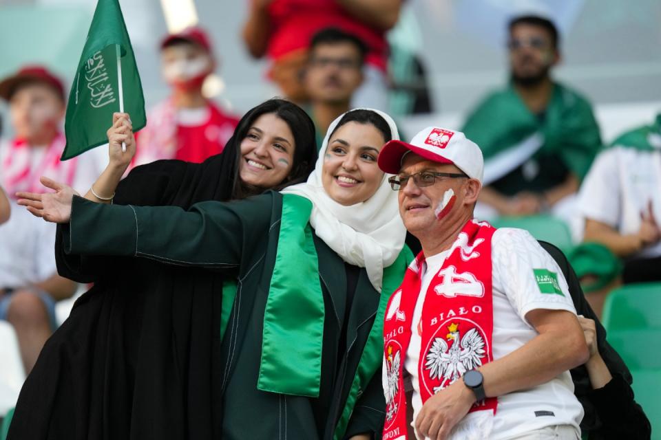 A Poland supporter poses with Saudi supporters prior to the World Cup group C football match between Poland and Saudi Arabia, at the Education City Stadium in Al Rayyan, Qatar, Saturday, Nov. 26, 2022. (AP Photo/Aijaz Rahi)