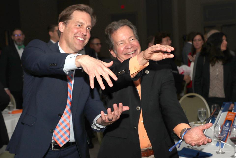New University of Florida President Ben Sasse, left, does the "Gator Chomp" with Root Co. President Phil Maroney on Tuesday night during the Daytona Regional Chamber of Commerce meeting at the Hilton Daytona Beach Oceanfront Resort. Sasse, who resigned as a U.S. senator representing Nebraska, was the featured guest at the event on his second day on the job.