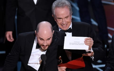 La La Land producer Jordan Horowitz announces the correct winner of Best Picture, while Warren Beatty looks on uncomfortably. - Credit: Chris Pizzello/Invision/AP