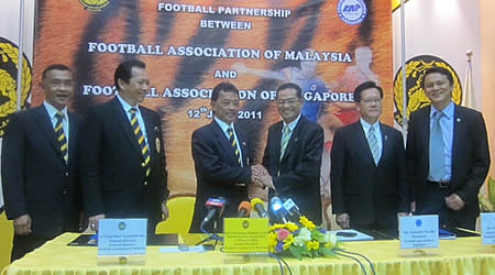 FAS president Zainudin Nordin (centre, right) shaking hands with his counterpart FAM deputy president Tengku Abdullah (centre, left). (Photo courtersy of FAS)