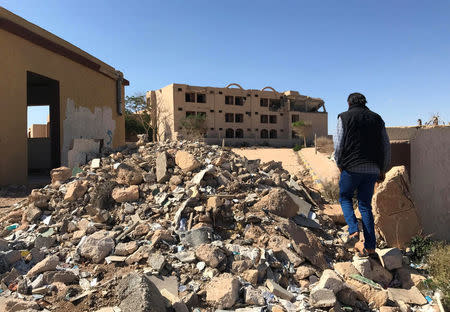 A Libyan man walks towards a hotel damaged during the NATO-backed campaign in 2011, in the city of Bani Walid, Libya October 29, 2017.REUTERS/Ulf Laessing