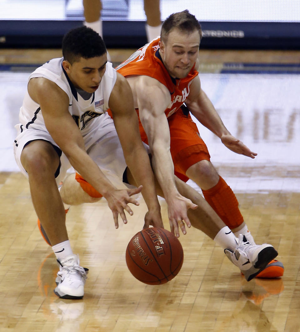 Pittsburgh's James Robinson, left, and Syracuse's Trevor Cooney go for a loose ball during the second half of an NCAA college basketball game on Wednesday, Feb. 12, 2014, in Pittsburgh. (AP Photo/Keith Srakocic)