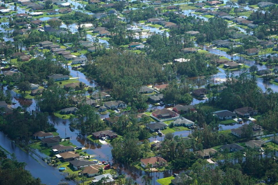 Homes are surrounded by floodwaters caused by Hurricane Ian on Sept. 29, in Fort Myers, Fla. Climate change added at least 10% more rain to Hurricane Ian, a study prepared immediately after the storm shows.