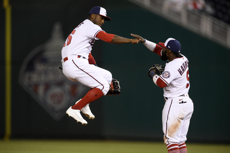 Washington Nationals center fielder Victor Robles, left, and second baseman Josh Harrison celebrate the team's 3-2 win in a baseball game against the St. Louis Cardinals, Tuesday, April 20, 2021, in Washington. (AP Photo/Nick Wass)