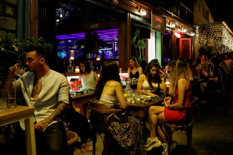 FILE PHOTO: People sit at a bar, amid the spread of the coronavirus disease (COVID-19), in Athens