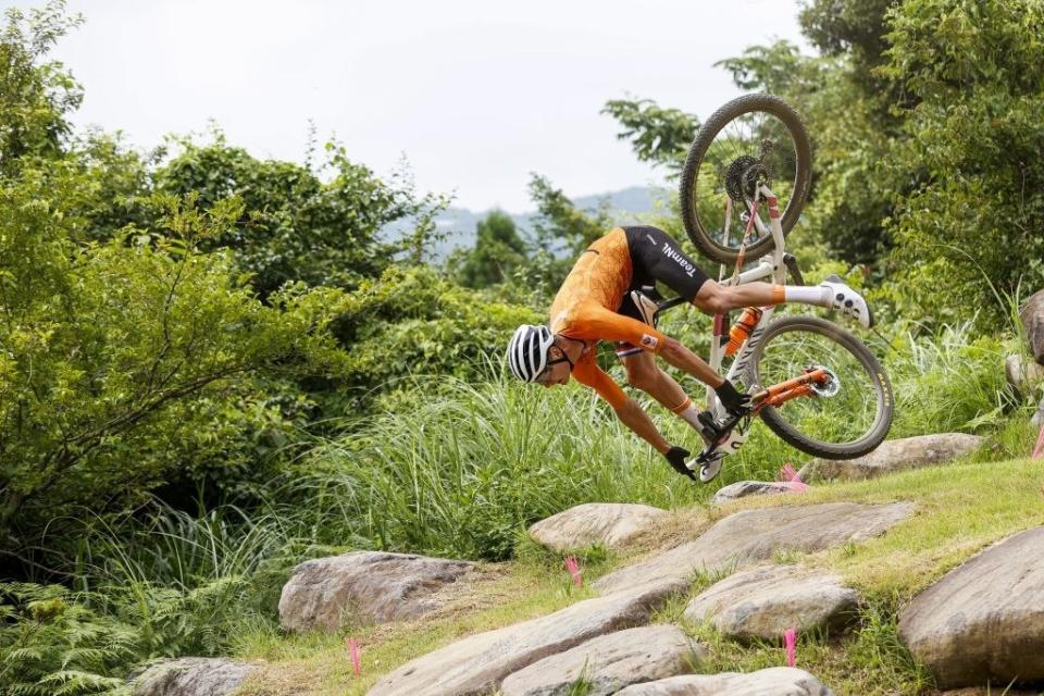 The mountain biker tilting forward while he's mid-air