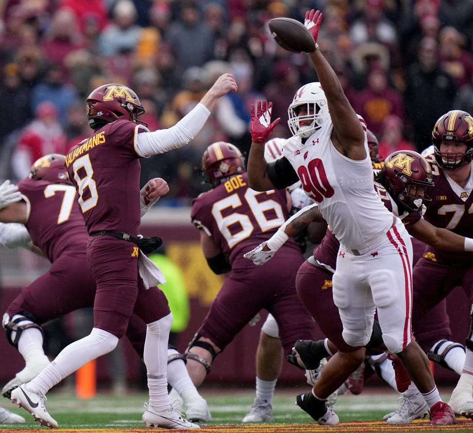 Wisconsin defensive end James Thompson Jr. (90) bats away a pass by Minnesota quarterback <a class="link " href="https://sports.yahoo.com/ncaaf/players/322931" data-i13n="sec:content-canvas;subsec:anchor_text;elm:context_link" data-ylk="slk:Athan Kaliakmanis;sec:content-canvas;subsec:anchor_text;elm:context_link;itc:0">Athan Kaliakmanis</a> (8) during the first quarter of their game Saturday, November 25, 2023 at Huntington Bank Stadium in Minneapolis, Minnesota. Wisconsin beat Minnesota 28-14.